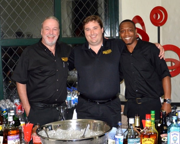 Three Bartenders Express bartenders in black company shirts behind a home bar